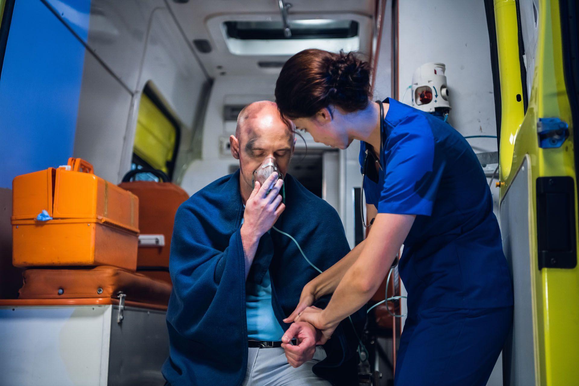 Une ambulancière et une victime d'un incendie à l'arriére d'une ambulance