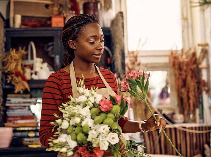 Fleuriste entrain de créer une composition florale