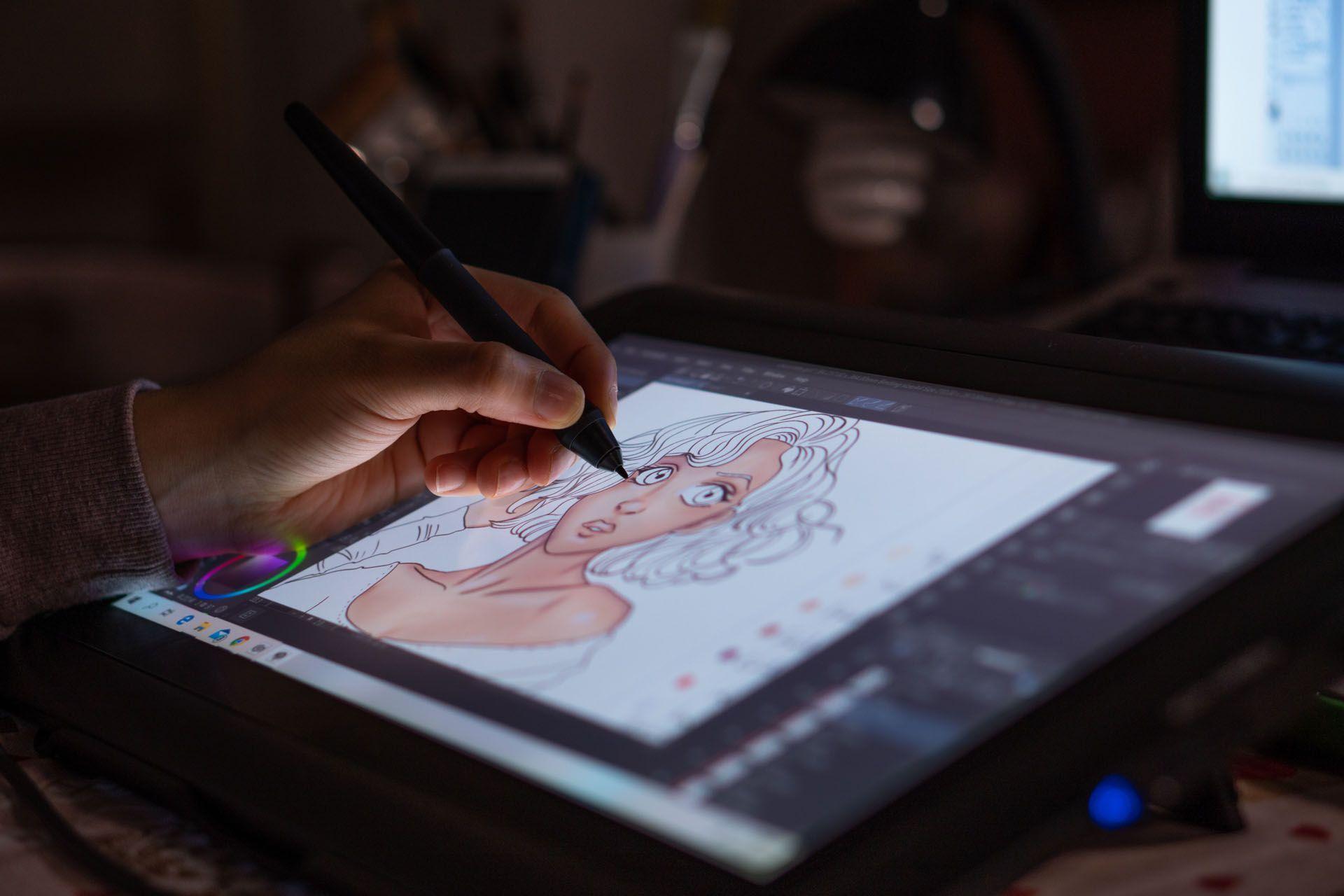 La main d'un dessinateur entrain de créer sur une tablette un dessin