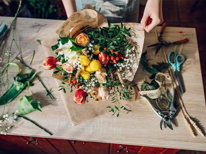 Fleuriste entrain de composer une création florale